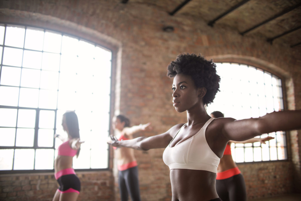 African American woman is practicing yoga in a brick studio